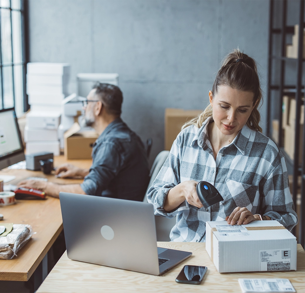 Woman business manager scanning code on box