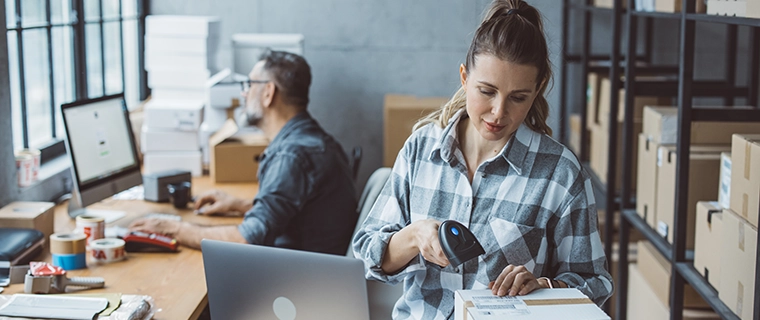 Woman business manager scanning code on box