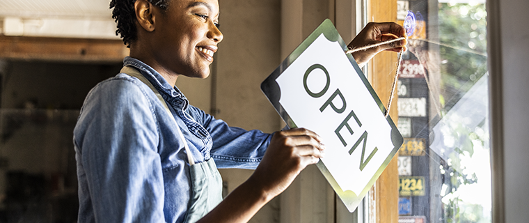 Black woman flipping sign in business window to 