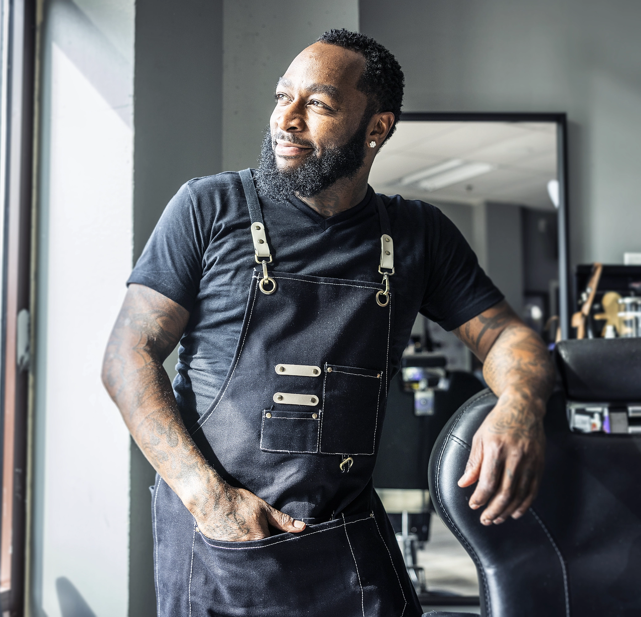 Man in apron smiling and looking out the window