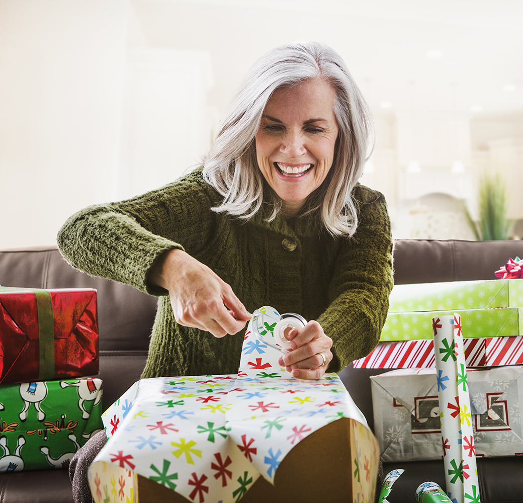 Older woman wrapping Christmas presents