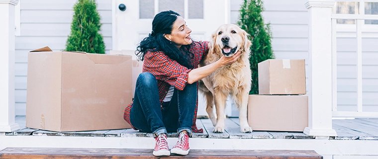 Woman sitting outside of her house and petting her dog
