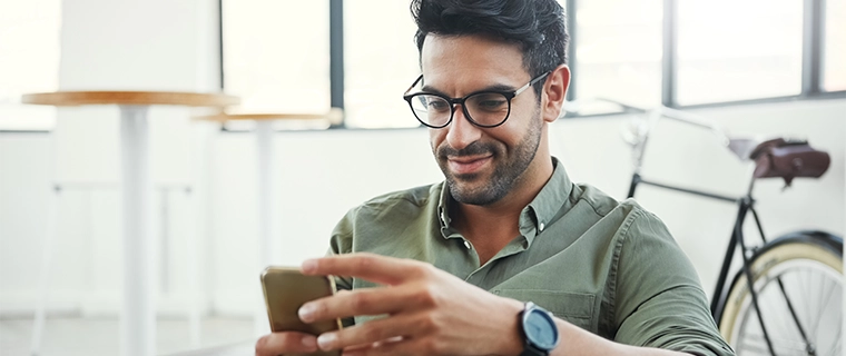 Man looking at his cellphone and smiling