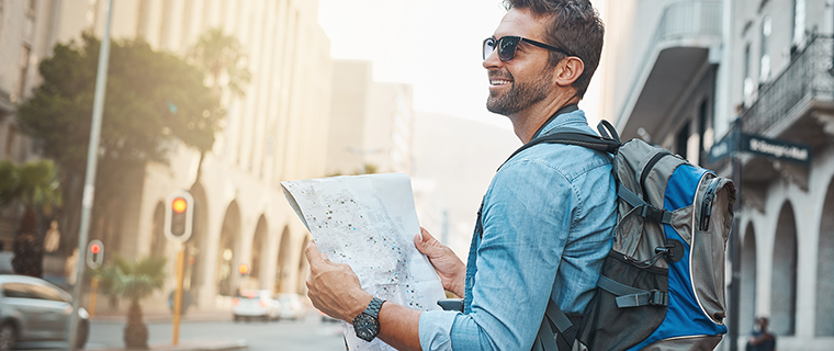 Man wearing sunglasses holding a map