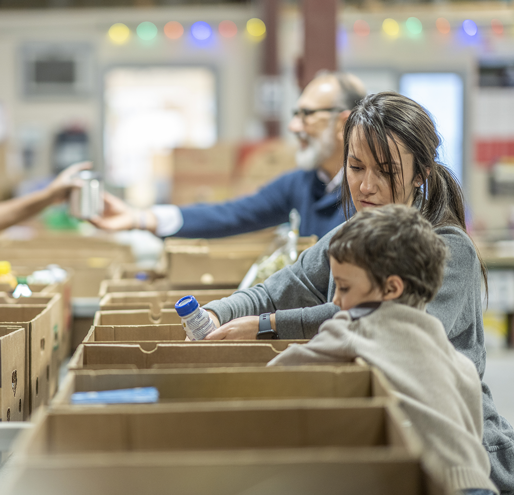 Mom and son at food bank loading items into boxes